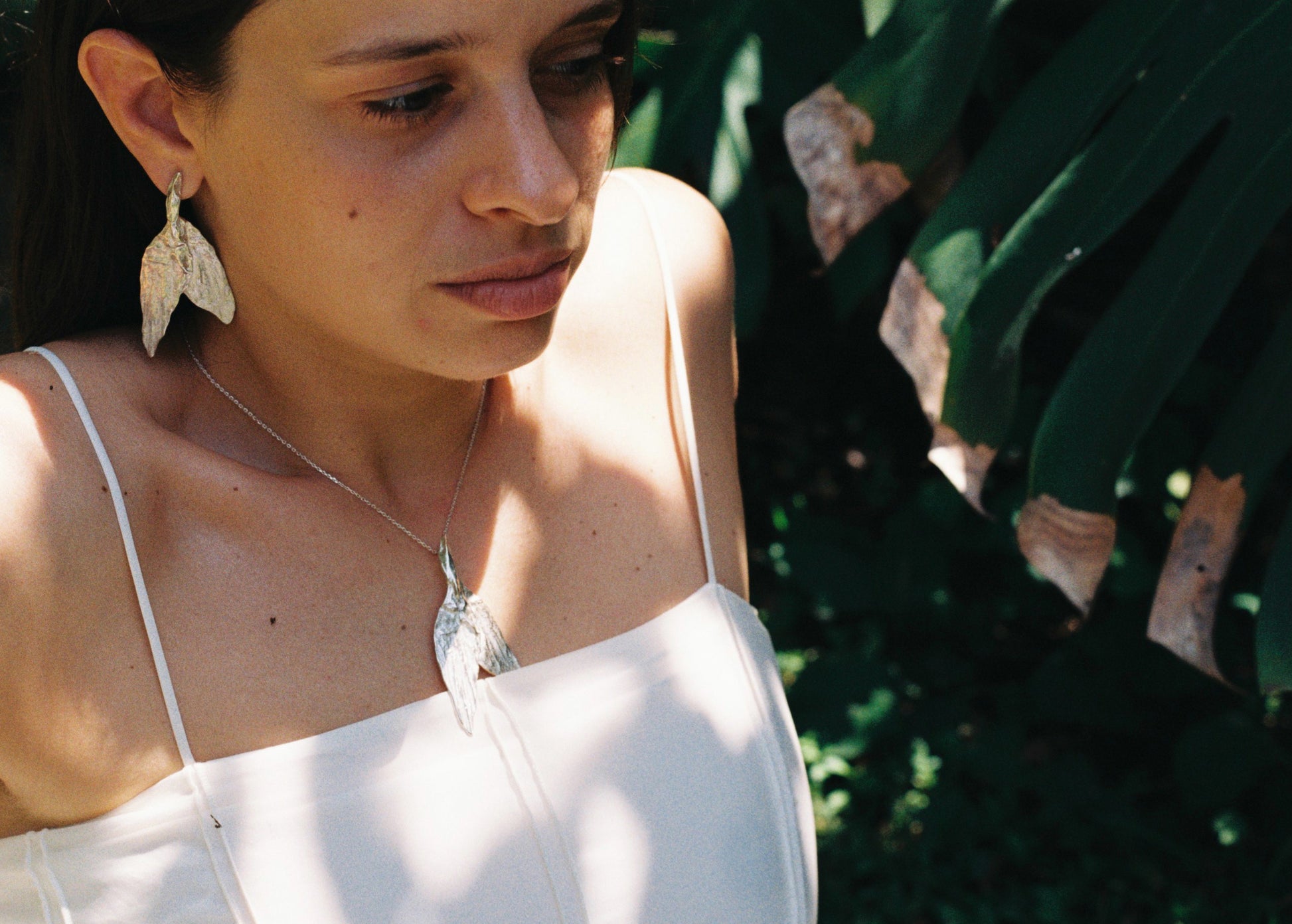 sculptural organic pendant resembling a leaf or wing